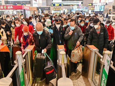 Des voyageurs portant des masques de protection contre le coronavirus s'apprêtent à monter dans un train à destination de Wuhan, le 28 mars 2020 à la gare de Shanghai - Hector RETAMAL [AFP]