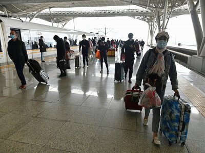 Des voyageurs descendent d'un train à la gare de Wuhan, le 28 mars 2020 dans la province chinoise du Hubei - HECTOR RETAMAL [AFP]
