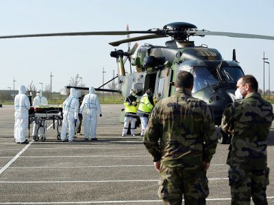 Des équipes médicales transportent un patient Des équipes médicales transportent un patient contaminé par le Covid-19 pour l'évacuer à bord d'un hélicoptère vers l'hôpital d'Essen, en Allemagne, le 28 mars 2020 sur un parking près du CHR de Metz - JEAN-CHRISTOPHE VERHAEGEN [AFP]