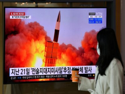 Une femme passe devant un écran de télévision diffusant des images d'un tir de missile nord-coréen, le 29 mars 2020 dans une gare de Séoul, en Corée du Sud - Jung Yeon-je [AFP]