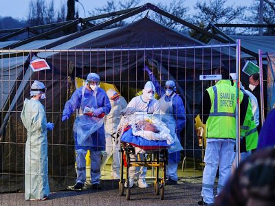 Des équipes médicales transfèrent des patients contaminés par le coronavirus d'un hôpital militaire pour les évacuer dans un TGV médicalisé vers des hôpitaux de la Nouvelle-Aquitaine, le 29 mars 2020 à Mulhouse - SEBASTIEN BOZON [AFP]