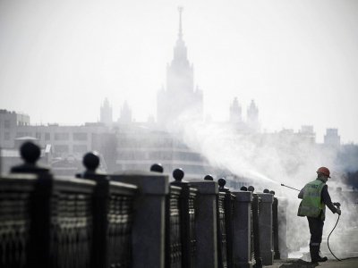 Un agent municipal désinfecte les bords des quais à Moscou, devant l'université d'Etat, le 28 mars 2020 - Alexander NEMENOV [AFP]