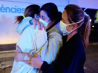 Accolade entre infirmières en Espagne, à l'hôpital de La Fe à Valence le 26 mars 2020 - JOSE JORDAN [AFP]