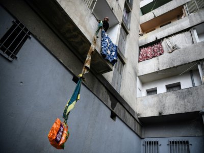 Un habitant souffrant du quartier Maison Blanche (Marseille) hisse chez lui  de la nourriture offerte par ses voisins, le 31 mars 2020 - Anne-Christine POUJOULAT [AFP]