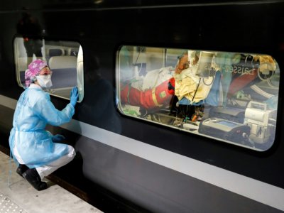 Une infirmière surveille l'installation d'un malade dans un train médicalisé à la Gare d'Austerlitz à Paris, le 1er avril 2020 - Thomas SAMSON [POOL/AFP]