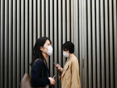 Deux femmes portent un masque de protection pendant l'épidémie de coronavirus, le 18 mars 2020 à Tokyo, au Japon - CHARLY TRIBALLEAU [AFP/Archives]