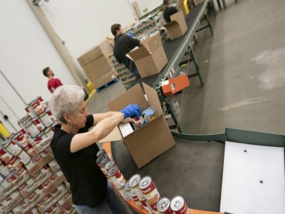 Des bénévoles de la Banque alimentaire de Washington préparent des cartons de nourriture, le 1er avril 2020 - Alex Edelman [AFP]