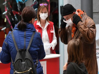 Des employés distribuent des masques aux clients d'un supermarché à Vienne le 1er avril 2020 - HELMUT FOHRINGER [APA/AFP]