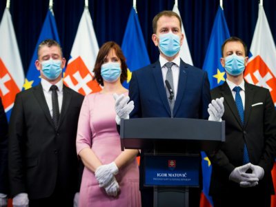 Paré de masque et de gants, le nouveau Premier ministre slovaque Igor Matovic, entouré de ses ministres, présente son nouveau gouvernement à la presse à Bratislava le 21 mars 2020 - VLADIMIR SIMICEK [AFP/Archives]