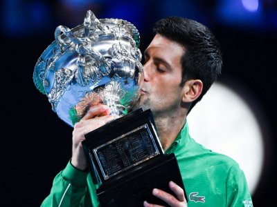Novak Djokovic embrasse le trophée de l'Open d'Australie après sa victoire en finale à Melbourne contre Dominic Thiem  le 3 février 2020 - William WEST [AFP/Archives]