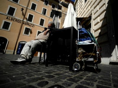 Un SDF dort dans une rue déserte de Rome, le 1er avril 2020 en Italie - Filippo MONTEFORTE [AFP]