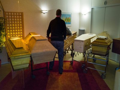Un employé d'une entreprise de pompes funèbres range des cercueils entreposés, le 1er avril 2020 à Mulhouse (Haut-Rhin) - SEBASTIEN BOZON [AFP]