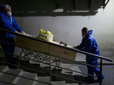 Deux employés d'une entreprise de pompes funèbres poussent un cercueil, le 1er avril 2020 à Mulhouse (Haut-Rhin) - SEBASTIEN BOZON [AFP]