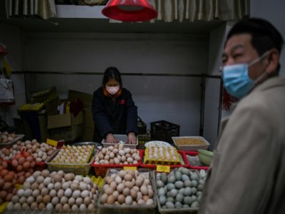 Un homme fait ses courses sur un marché de Wuhan, en Chine, le 2 avril 2020 - Hector RETAMAL [AFP]