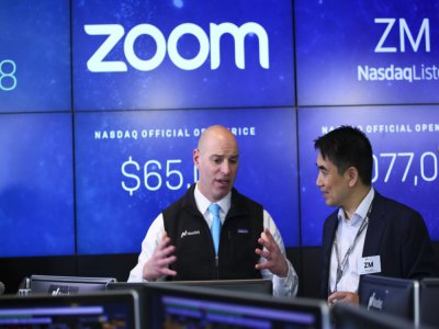 Le fondateur de Zoom, Eric Yuan (droite), parle avec un courtier au Nasdaq (New York) en avril 2019 lors de l'introduction en Bourse de sa société - KENA BETANCUR [GETTY IMAGES NORTH AMERICA/AFP/Archives]