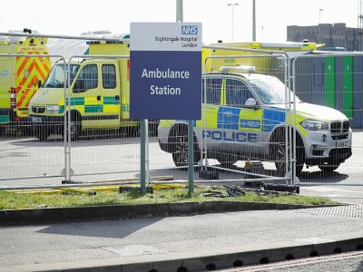 Un véhicule de police stationné devant l'entrée du Centre des expositions ExCeL London reconverti en hôpital de campagne pour accueillir des malades du nouveau coronavirus, le 3 avril 2020 à Londres - Tolga AKMEN [AFP]