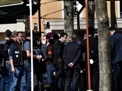Le ministre de l'Intérieur Christophe Castaner (C) s'entretient avec des policiers à Romans-sur-Isère, théâtre d'une attaque au couteau, le 4 avril 2020 - JEFF PACHOUD [AFP]