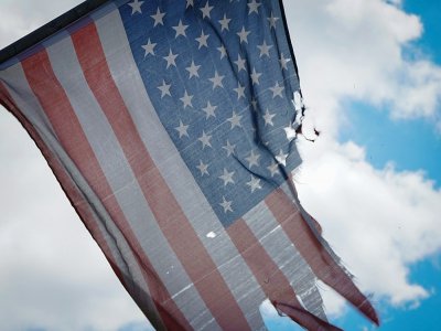Un drapeau américain déchiré flotte sur une grille devant l'hôpital Wyckoff à Brooklyn, le 04 avril 2020 - Bryan R. Smith [AFP]