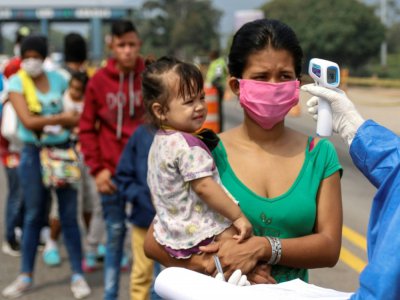 Des employés du ministère de la Santé prennent la température de Vénézuéliens retournant au pays depuis la Colombie, le 4 avril 2020 sur le pont international Simon Bolivar, à Cucuta - Schneyder MENDOZA [AFP]