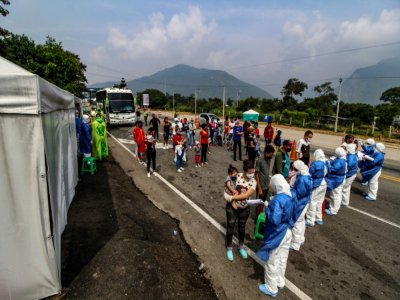Des employés du ministère de la Santé contrôlent des Vénézuéliens retournant au pays depuis la Colombie, le 4 avril 2020 sur le pont international Simon Bolivar, à Cucuta - Schneyder MENDOZA [AFP]