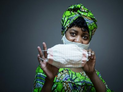La camerounaise Florence pose avec un masque qu'elle a réalisé pour l'organisation caritative de l'Armée du Salut, à Paris le 6 avril 2020 - JOEL SAGET [AFP]