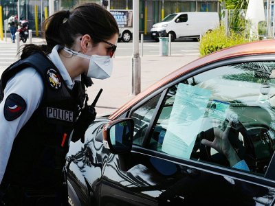 Une policière contrôle un automobiliste le 6 avril 2020 à Nice, après trois semaines de confinement. - VALERY HACHE [AFP]