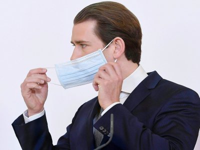 Le chancelier autrichien  Sebastian Kurz enlève sa masque de protection lors d'une conférence de presse le 6 avril 2020 à Vienne portant sur l'épidémie de coronavirus. - HELMUT FOHRINGER [APA/AFP]
