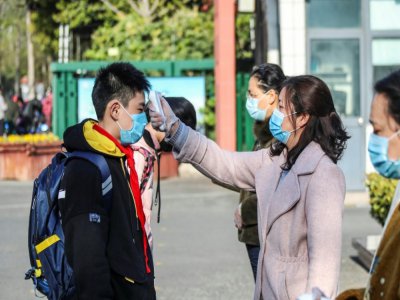 Contrôle de la température, le 7 avril 2020 à Huaian, dans l'est de la Chine - STR [AFP]