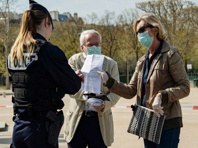 Des policiers contrôlent des promeneurs à Paris près de la Tour Eiffel le 7 avril 2020 - BERTRAND GUAY [AFP]
