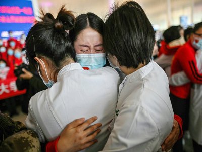 Retrouvailles entre proches après la réouverture de l'aéroport de Wuhan, le 8 avril 2020 - Hector RETAMAL [AFP]