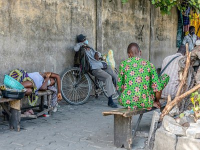 Un homme se repose sur sa bicyclette et porte un masque de protection contre le coronavirus à Cotonou le 8 avril 2020 - Yanick Folly [AFP]