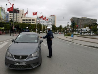 Photo d'archives montrant un policier tunisien contrôlant un véhicule le 24 mars 2020 dans la capitale Tunis - FETHI BELAID [AFP]