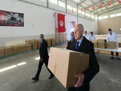 Photo fournie par le service de presse de la présidence tunisienne montrant le président tunisien Kais Saied participant à une distribution d'aide en pleine crise du coronavirus le 5 avril 2020 à Gammarth, en banlieue nord de la capitale Tunis - - [TUNISIAN PRESIDENCY/AFP]