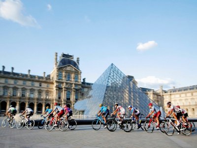 Le peloton passant devant la pyramide du Louvres à Paris lors de la dernière étape du Tour de France 2019  entre Rambouillet et les Champs Elysées, le 28 juillet. - PHILIPPE WOJAZER [POOL/AFP/Archives]