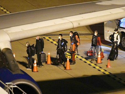 Des passagers évacués du paquebot australien Greg Mortimer attendent pour monter dans un avion à destination de Melbourne, le 11 avril 2020 à l'aéroport de Ciudad de la Costa, près de Montevideo, en Uruguay - Eitan ABRAMOVICH [AFP]