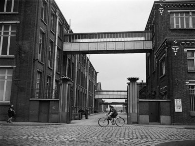 Une femme sur un vélo passe devant une usine textile en septembre 1945 à Roubaix - - [AFP/Archives]