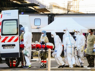 Des personnels soignants installent dans une ambulance un patient atteint du Covid-19 après son arrivée en TGV médicalisé, le 10 avril 2020 à la gare de Bordeaux - MEHDI FEDOUACH [AFP]