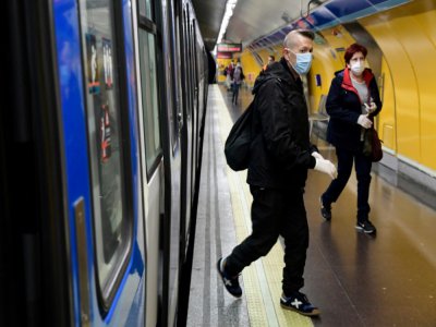Des personnes, gantées et masquées pour se protéger du coronavirus, sortent du train à la gare d'Atocha, le 13 avril 2020 à Madrid - JAVIER SORIANO [AFP]