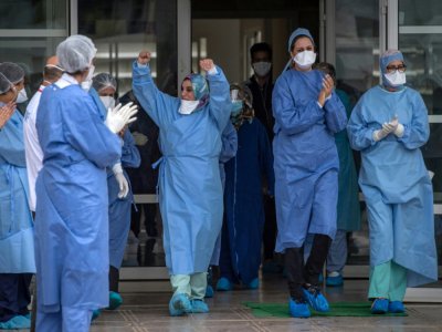 Des personnels soignants applaudissent la sortie de patients guéris du Covid-19, le 12 avril 2020 à Rabat, au Maroc - FADEL SENNA [AFP]