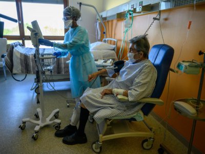 Une infirmière prend la tension d'un malade du Covid-19 dans un centre de rééducation fonctionnelles d'Illkirch-Graffenstaden , le 14 avril 2020 - PATRICK HERTZOG [AFP]