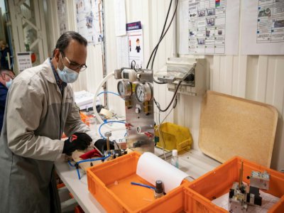Un employé du groupe automobile PSA assemble les pièces d'un respirateur médical, le 15 avril 2020 à l'usine de Poissy, au nord-ouest de Paris - Thomas SAMSON [AFP]
