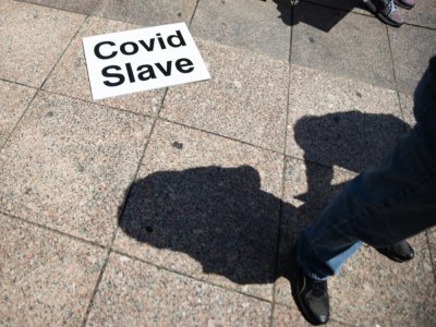 Une affichette "esclave du Covid" à Columbus (Ohio, Etats-Unis), le 18 avril 2020 lors d'une manifestation contre le confinement - Megan JELINGER [AFP]