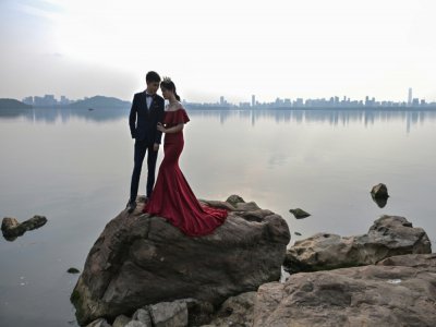 Un couple pose pour une photo de mariage, près d'un lac à Wuhan, dans la province du Hubei, en Chine, le 19 avril 2020 - Hector RETAMAL [AFP]