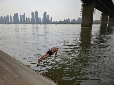 Un homme plonge dans le fleuve Yangtze, à Wuhan, en Chine, le 16 avril 2020 - Hector RETAMAL [AFP]