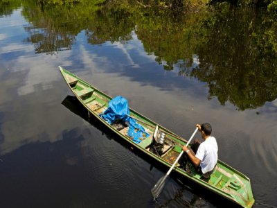 Eder Rodrigues do Nascimento navigue sur le rivière Jurua au Brésil avec son accordéon le 14 mars 2020 - FLORENCE GOISNARD [AFP]