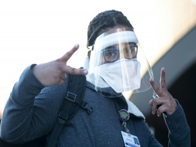 Un personnel soignant fait le signe de la victoire à son entrée au Elmhurst Hospital le 22 avril 2020 situé dans le quartier de Queens à New York. - Johannes EISELE [AFP]