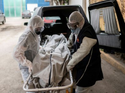 Des employés d'un crématorium transportent le corps d'une victime du Covid-19, à Cuautitlan Izcalli (Mexique), le 23 avril 2020 - PEDRO PARDO [AFP]