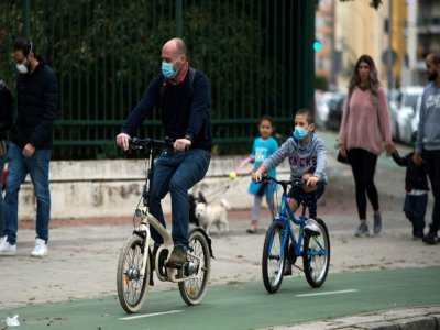 Un père et son fils en vélo dans une rue de Séville (Espagne), le 26 avril 2020 - CRISTINA QUICLER [AFP]