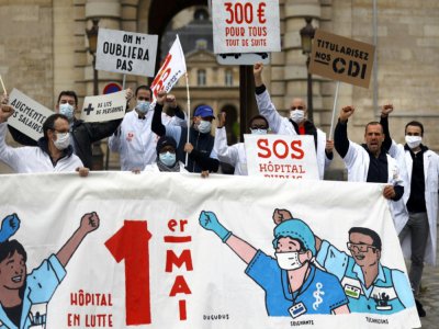Des personnels soignants et membres du syndicat français CGT manifestent le 30 avril 2020 devant l'hôpital public parisien de la La Pitié Salpêtrière à la veille du 1er mai. - THOMAS COEX [AFP]