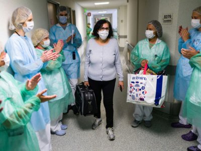 Malika Fisli, atteinte par le coronavirus en mars, quitte l'unité de médecine physique et réadaptation de l'hôpital Emile Muller sous les applaudissements des personnels soignants, le 29 avril 220 à Mulhouse - SEBASTIEN BOZON [AFP]